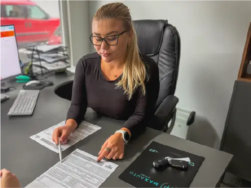 Poradkyňa MAXAUTO pri stole s dokumentmi k financovaniu