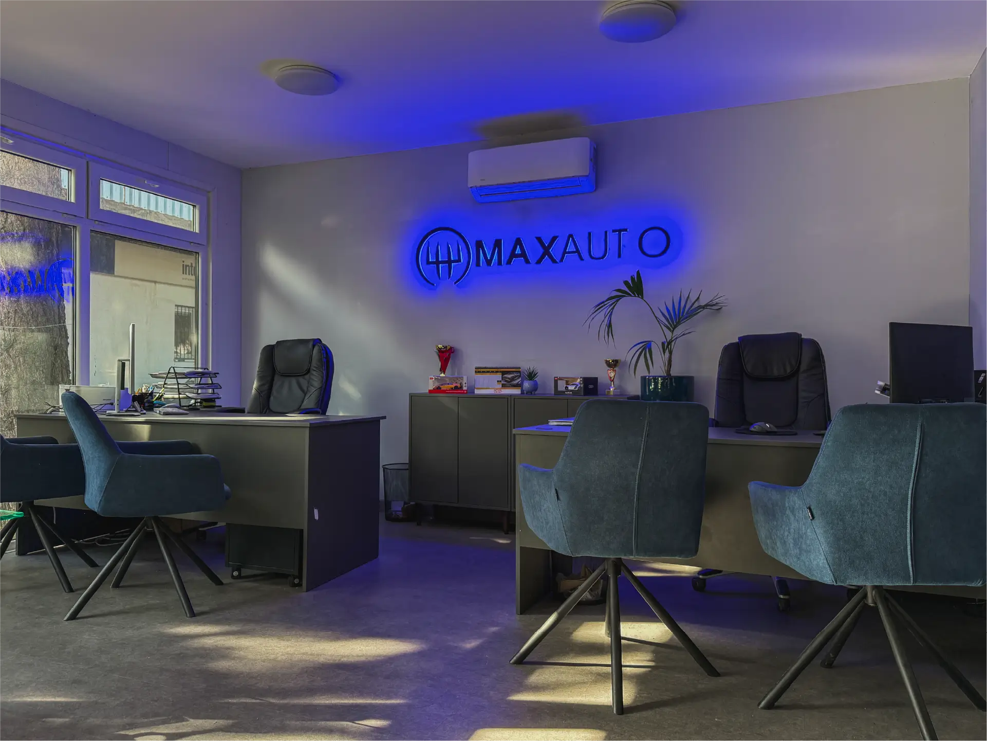 Predajňa Maxauto s podsvieteným logom na stene